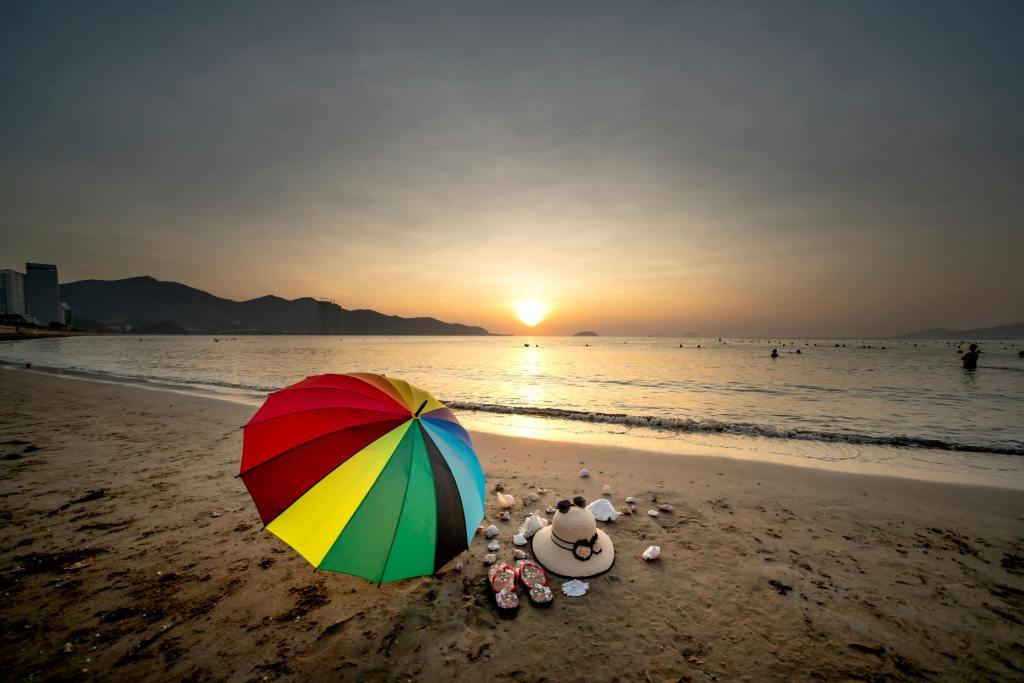 An umbrella on a beach at sunset